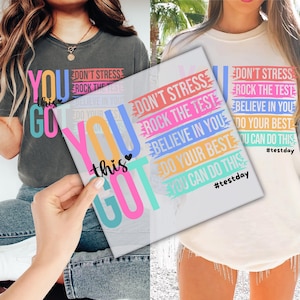 May include: Two white t-shirts with colorful text that reads "You got this" and "Don't stress, rock the test, believe in you, do your best, you can do this #testday".