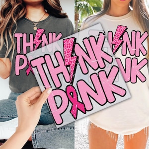 May include: Two t-shirts, one gray and one cream, each with the words "THANK PINK" in pink block letters. The letter "K" is a pink lightning bolt with a leopard print design. A pink ribbon is also featured.