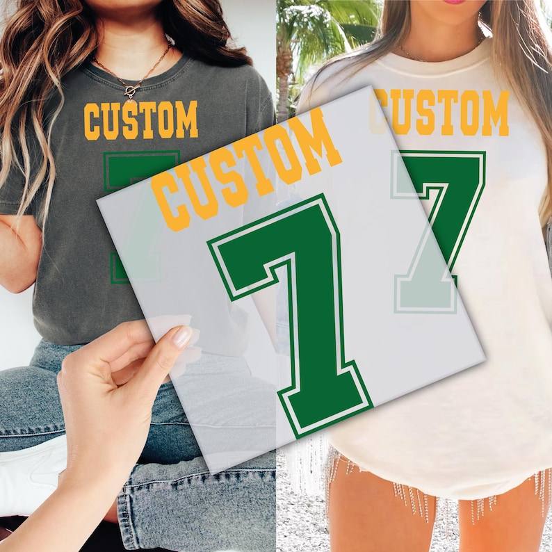 Peut inclure: Deux t-shirts, un gris et un cr&egrave;me, chacun avec le mot "CUSTOM" en lettres majuscules dor&eacute;es. Un motif avec le chiffre "7" en vert avec un contour blanc est visible sur un calque transparent. Les t-shirts sont des v&ecirc;tements d&eacute;contract&eacute;s.