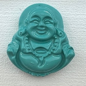 May include: A teal green jade carving of a smiling Buddha figurine.