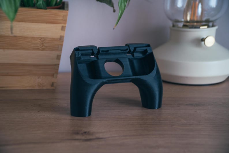 K&ouml;nnte beinhalten: Eine wei&szlig;e Keramik-Tasse mit schwarzem Henkel und dem Text "But First, Coffee" in schwarzer, fetter Schrift. Die Tasse steht auf einer Holzoberfl&auml;che.