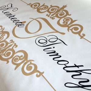 May include: A white banner with the names "Renee" and "Timothy" written in black cursive script. The names are separated by a gold decorative design. The date "SEP 26" is written in black at the bottom left corner.