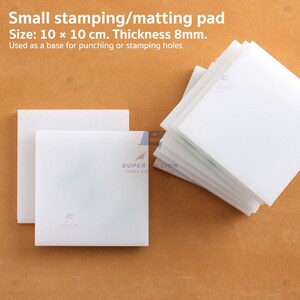 May include: White square stamping/matting pads. Each pad measures 10 x 10 cm with an 8mm thickness. The pads are used as a base for punching or stamping holes. The image includes the text "Small stamping/matting pad" and "SUPER BILLION TOOLS & A".