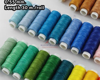 Op de afbeelding: Spoelen van ronde waspolyesterdraad in verschillende kleuren, waaronder blauw, groen, geel en oranje. De tekst op de afbeelding luidt "Round Wax Polyester Thread 0.55 mm. Length 30 m./roll."