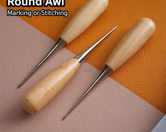 May include: Three round awls with wooden handles and metal tips. The text "Round Awl Marking or Stitching" is displayed in the upper left corner. The awls are arranged on a textured surface with shades of orange, pink, and blue.