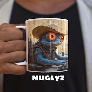 May include: White ceramic mug featuring a blue frog character wearing a cowboy hat and goggles, working on a computer. The mug has a binary code background and the word "MUGLYZ" at the bottom.