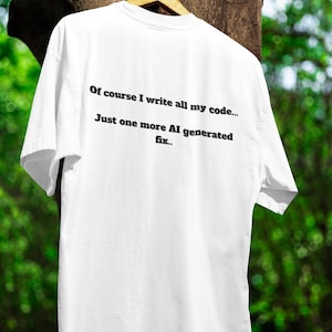 May include: White t-shirt with black text that reads "Of course I write all my code... Just one more AI generated fix..."