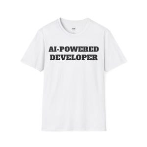 以下が含まれることがあります： 黒文字で「AI-POWERED DEVELOPER」と書かれた白いTシャツです。