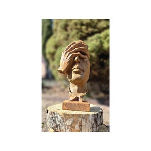 Antique cast iron sculpture worried face. Rustic figurine garden and home decoration. Beautiful and stylish cast iron sculpture
