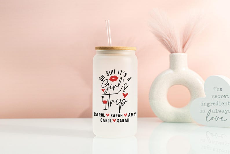 May include: Frosted glass tumbler with a bamboo lid and straw. The tumbler features the text "Oh Sip! It's a Girl's Trip" with a lipstick kiss, hearts, and a cocktail illustration. Names are listed below the text.