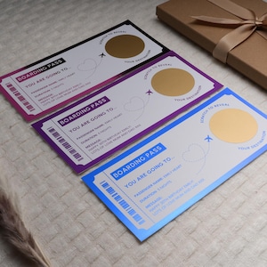 Op de afbeelding: Drie kleurrijke instapkaartjes met een gouden krasgebied om een bestemming te onthullen. De kaartjes hebben een vliegtuig- en hartontwerp. De tekst op de kaartjes luidt "Boarding Pass You Are Going To..."