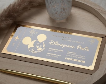 May include: A gold-trimmed invitation card with a Mickey Mouse illustration and the text "Pack your bags, you are going to Disneyland Paris". The card also includes the text "Passenger Name: Emily Heart" and "Departure Date: 25th Jan 2025".