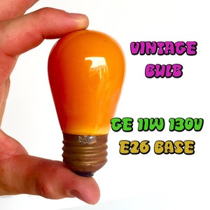 May include: A vintage orange light bulb with a GE 11W 130V E26 base.