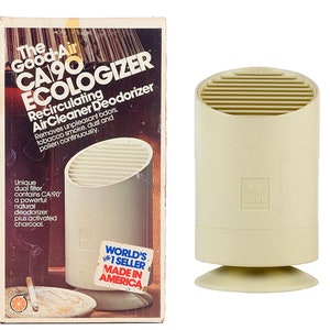 May include: A beige air purifier with a rectangular box featuring the text "The Good-Air CA 90 ECOLOGIZER Recirculating Air Cleaner Deodorizer" and a sticker that says "World's #1 Seller Made in America".