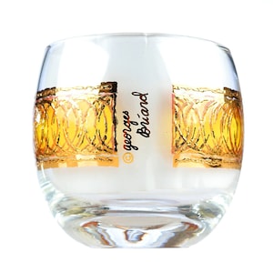 May include: A clear glass tumbler with a gold rim and a gold design. The glass has the text "Georges Briard" printed on it.