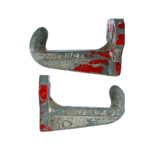 May include: Four metal hooks with a gray and red paint finish. The hooks are labeled "Sno-Fog" and have a unique curved shape.