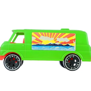 May include: A green toy van with a sunrise and mountain scene on the side. The van has black wheels with "AMLOID" written on them.