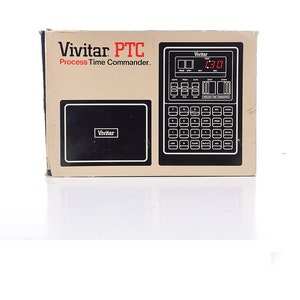 May include: A brown cardboard box with a black and white image of a Vivitar PTC Process Time Commander. The box has the text "Vivitar PTC Process Time Commander" printed on it.