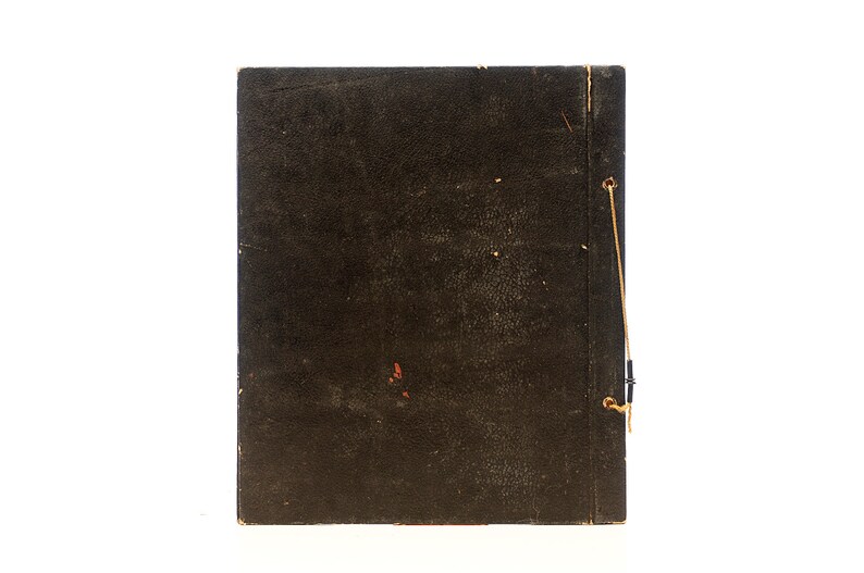May include: A dark brown, worn, leather-bound book with a string closure. The book is closed and the spine is visible.