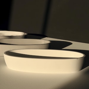 May include: A set of three ceramic mugs with a speckled, matte finish. Each mug features a different color: light blue, cream, and gray. The mugs have a simple, modern design and a comfortable handle.