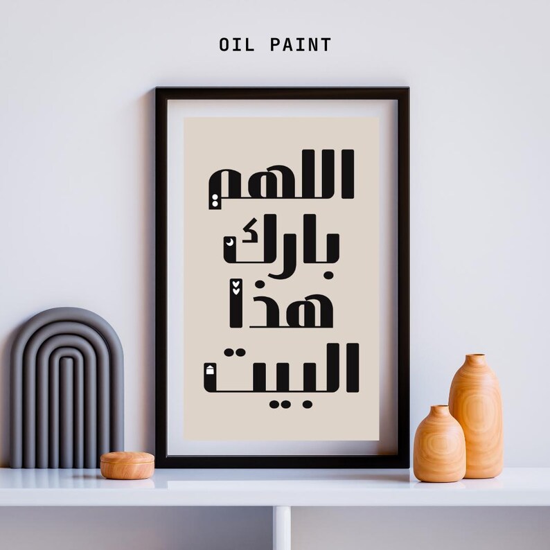 Op de afbeelding: Een ingelijste kunstdruk met zwarte Arabische kalligrafie op een beige achtergrond. De woorden zijn verticaal gestapeld. De lijst is zwart. De woorden "OIL PAINT" staan bovenaan. Houten vazen en een grijze boog staan op de plank.