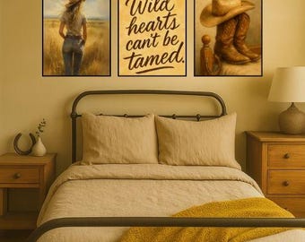 May include: Three framed wall art pieces. The left panel depicts a person in a field wearing a hat. The center panel has the text "Wild hearts can't be tamed." The right panel shows a cowboy hat and boots. The art is displayed above a bed.