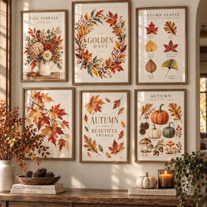 May include: A gallery wall set of six framed art prints featuring autumn themes, including floral arrangements, leaf wreaths, botanical leaf charts, maple branches, inspirational text, and pumpkin and mushroom illustrations in warm seasonal colors.