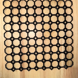May include: Black plastic grid with a hexagonal pattern. The grid is made up of small octagons with a circle in the center of each octagon.