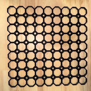 May include: Black plastic grid with a repeating hexagonal pattern. The grid is made of a series of connected octagons.