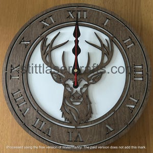 May include: A wooden wall clock with Roman numeral markings and a deer silhouette in the center. The clock face is white and the deer is brown.