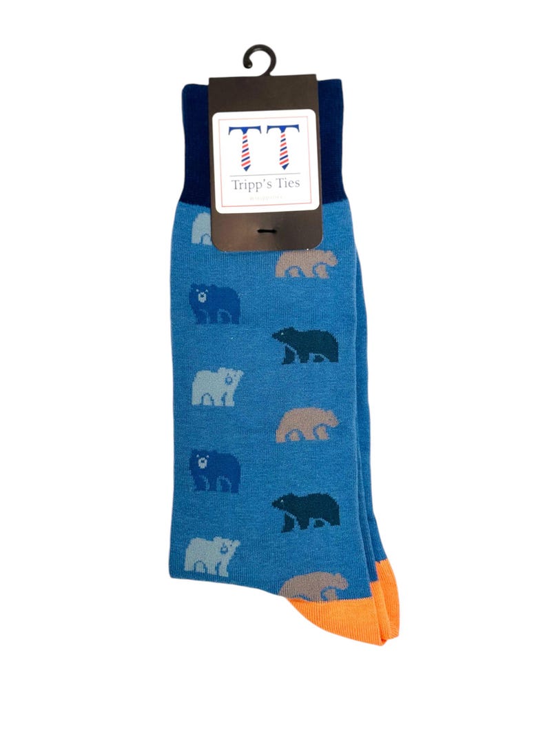 May include: Blue socks with a pattern of bears in different shades of blue, grey, and brown. The socks have an orange cuff and a tag that says "Tripp's Ties" with two stylised ties.