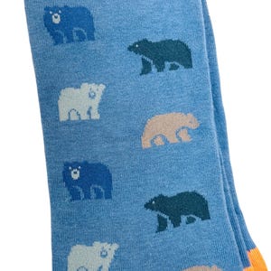 May include: A pair of blue socks with a pattern of different coloured bears. The socks have an orange cuff.