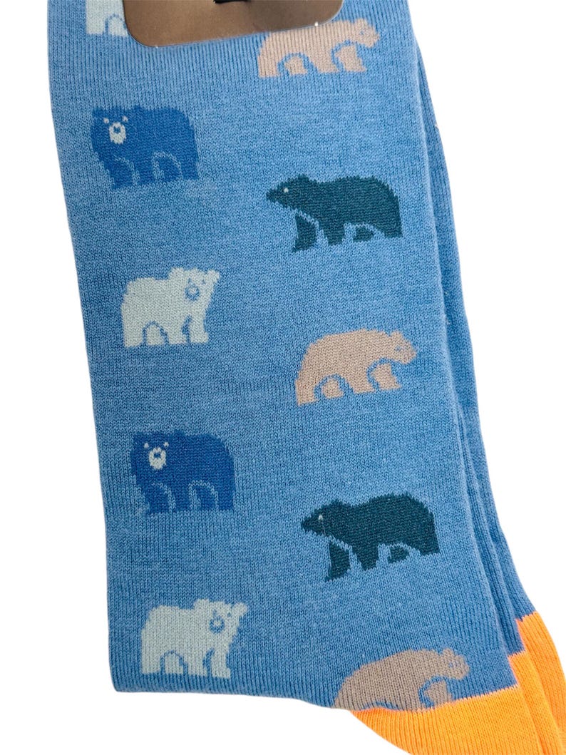 May include: A pair of blue socks with a pattern of different coloured bears. The socks have an orange cuff.