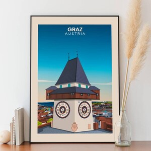 Può includere: Un'illustrazione colorata di una torre dell'orologio a Graz, Austria. La torre ha un tetto blu e una base in legno marrone. I quadranti dell'orologio sono bianchi con numeri romani neri e lancette nere. Il testo "GRAZ AUSTRIA" è stampato in nero nella parte superiore dell'immagine.