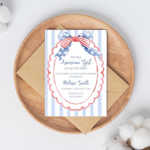 Könnte beinhalten: Eine Babyparty-Einladung mit patriotischem Thema. Die Einladung zeigt ein Aquarelldesign mit einer rot-weiß-blauen Schleife und dem Text "An All American Girl Is On The Way!". Die Einladung befindet sich auf einem gestreiften Hintergrund.