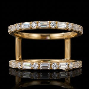 May include: A gold double-band ring featuring two parallel bands connected by vertical gold bars. Each band is set with an alternating pattern of clear baguette-cut and round brilliant-cut diamonds, creating a symmetrical and continuous design.