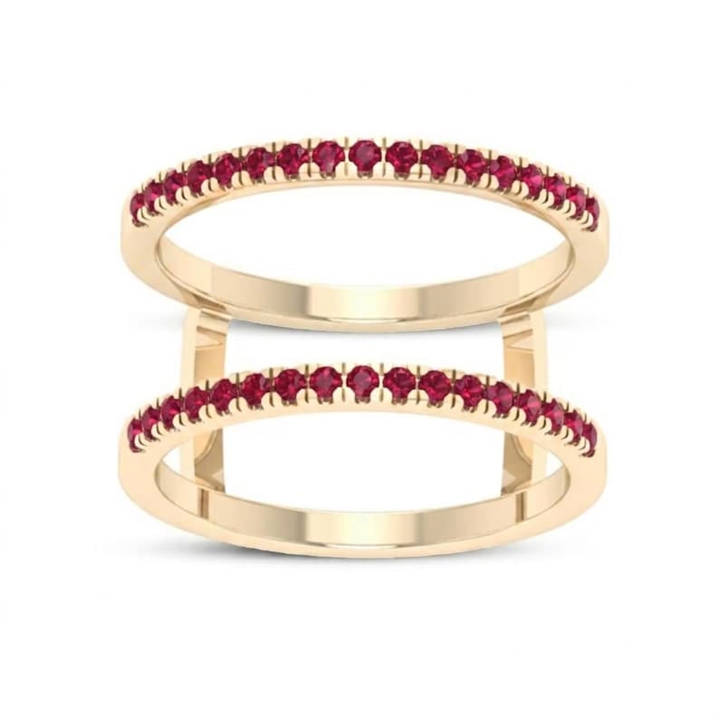 Pu&ograve; includere: Due anelli color oro, ciascuno adornato con una fila di piccole e vivaci pietre preziose rosse. Gli anelli sono impilati, creando un effetto a strati. Le pietre preziose sono uniformemente distanziate, aggiungendo un tocco di eleganza.