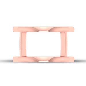 Puede incluir: Un anillo de oro rosa con un diseño abierto único. El anillo presenta dos bandas paralelas conectadas por barras verticales, creando un espacio rectangular abierto en el centro. El anillo tiene una superficie pulida y reflectante.