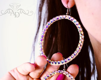 May include: A pair of large hoop earrings with a silver tone metal setting and a clear iridescent crystal design.
