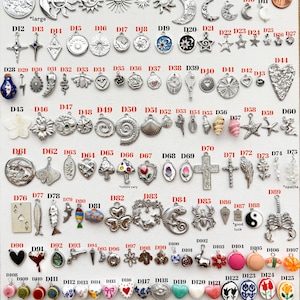 May include: A collection of assorted metal, ceramic, and shell charms labeled D1 through D142, featuring celestial, floral, animal, and geometric shapes. The display includes various silver-toned pendants, colorful beads, and small decorative items.
