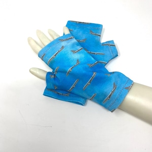 May include: A pair of blue fingerless gloves with a pattern of airplanes on them.
