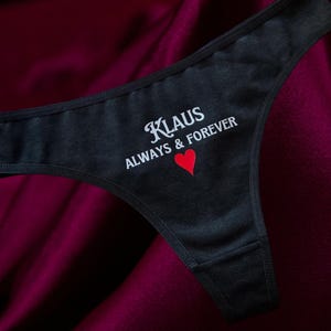 May include: Black lace underwear with the text "Klaus Always & Forever" and a red heart.