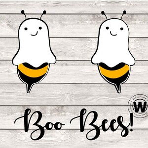 Könnte beinhalten: Zwei weiße, geisterförmige Figuren mit schwarzen Augen und lächelnden Mündern, jede mit einem schwarz-gelb gestreiften Bienenbauch. Der Text "Boo Bees!" ist in Schwarz unter den Figuren auf einem weißen Holzmaserungshintergrund geschrieben.