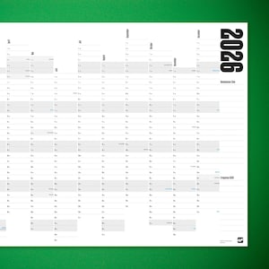 Peut inclure: Un grand planificateur annuel blanc pour l'année 2026, sur fond vert. Le calendrier présente une mise en page en grille avec les jours et les mois clairement indiqués. L'année 2026 est imprimée verticalement en gras noir.