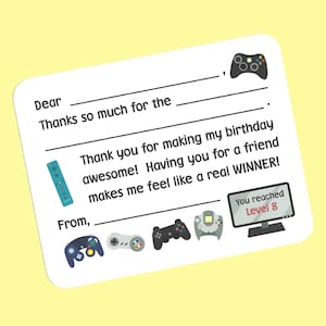 May include: A white thank you card with a video game theme. The card has a blank space for a name and a message. The card has a variety of video game controllers and a monitor with the text "You reached Level 8".