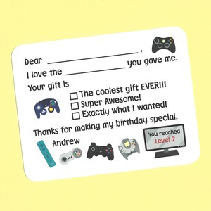 May include: A thank you card for a birthday gift, featuring a video game theme. The card has a blank space for the recipient's name and a check box to indicate how much the recipient liked the gift. The card also includes a variety of video game controllers and a screen displaying "You reached Level 7".