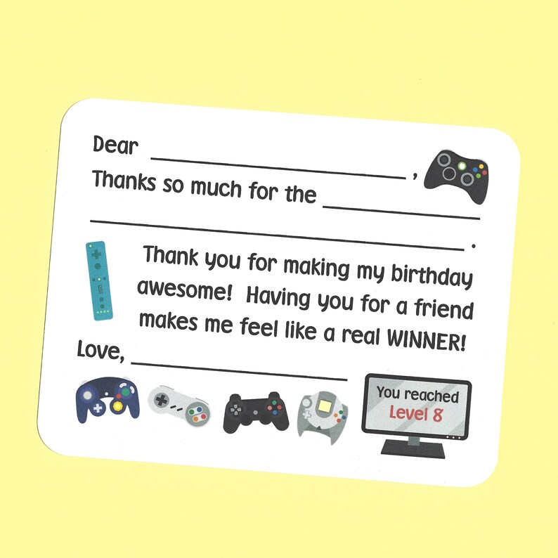 May include: A white thank you card with a video game theme. The card has a blank space for a name and a message. The card also has a variety of video game controllers and a computer screen with the text "You reached Level 8".
