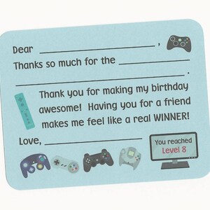 May include: A light blue thank you card with a video game theme. The card has a space to write "Dear" and "Love," and includes the text "Thanks so much for the..." and "Thank you for making my birthday awesome! Having you for a friend makes me feel like a real WINNER!" The card also features a variety of video game controllers and a screen that says "You reached Level 8."