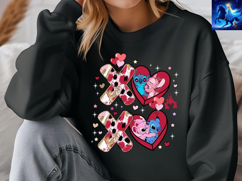 K&ouml;nnte beinhalten: Schwarzes Sweatshirt mit einem Valentinstagsdesign. Das Design zeigt zwei Paare von Zeichentrickfiguren in herzf&ouml;rmigen Rahmen mit den Buchstaben "X" und "O". Die Buchstaben haben ein rotes und goldenes Muster. Herzen und Sterne sind um das Design verstreut.