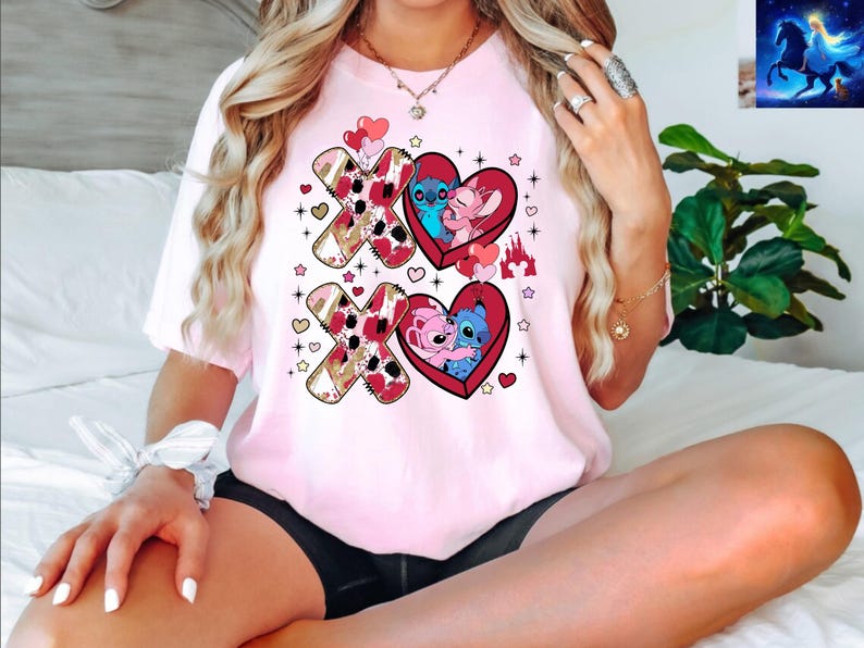 K&ouml;nnte beinhalten: Hellrosa T-Shirt mit einem Design mit den Charakteren Stitch und Angel aus Lilo & Stitch. Das Design umfasst rote Herzen, die Buchstaben X und O und ein Schloss. Das Shirt hat einen Rundhalsausschnitt und kurze &Auml;rmel.